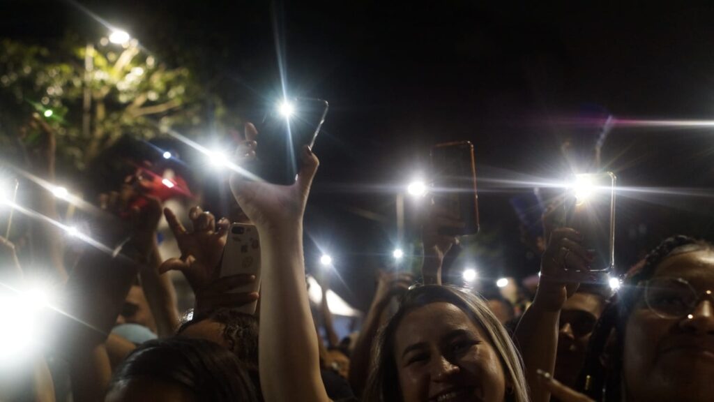 Plateia com luzes dos celulares acesas e apontadas para o alto durante show de Silvanno Salles.