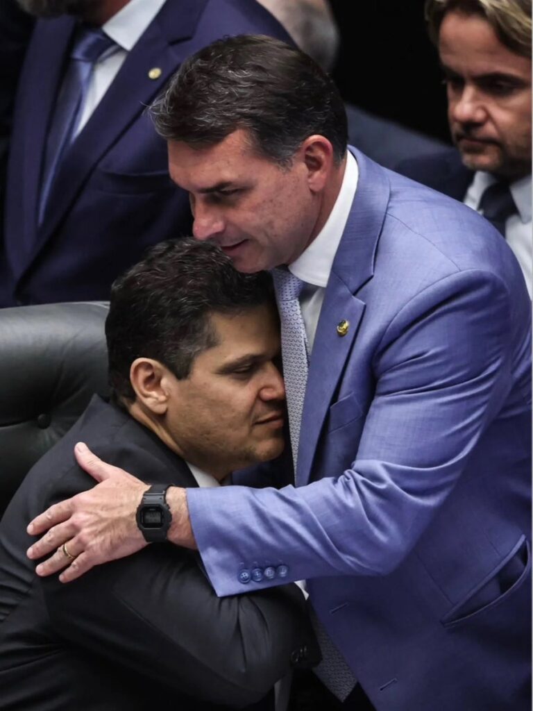 Foto que flagra abraço entre Davi Alcolumbre, presidente do Senado e o Senador Flávio Bolsonaro, filho do ex-presidente Jair Bolsonaro, candidato da direita à presidência deste ano
